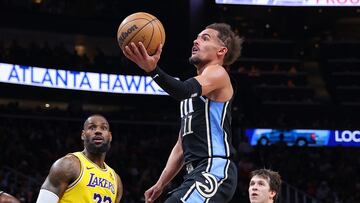 ATLANTA, GEORGIA - JANUARY 30: Trae Young #11 of the Atlanta Hawks drives against LeBron James #23 and Austin Reaves #15 of the Los Angeles Lakers during the third quarter at State Farm Arena on January 30, 2024 in Atlanta, Georgia. NOTE TO USER: User expressly acknowledges and agrees that, by downloading and/or using this photograph, user is consenting to the terms and conditions of the Getty Images License Agreement.   Kevin C. Cox/Getty Images/AFP. (Photo by Kevin C. Cox/Getty Images) (Photo by Kevin C. Cox / GETTY IMAGES NORTH AMERICA / Getty Images via AFP)