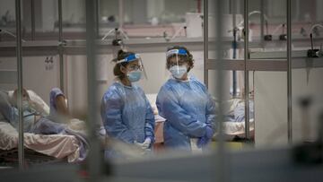 Imagen del interior del hospital de campaña de Ifema, donde dos profesionales sanitarias charlan.