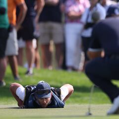El caddie de Patrick Reed lee un put sobre la hierba