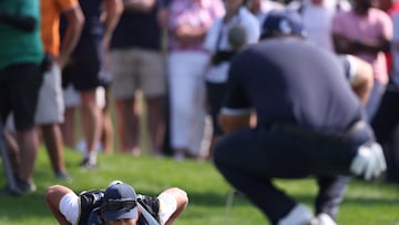 El caddie de Patrick Reed lee un put sobre la hierba