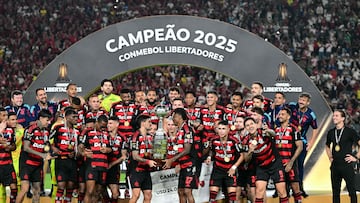 Flamengo's forward #27 Bruno Henrique (R) and Uruguayan midfielder #10 Giorgian de Arrascaeta (L) lift the trophy with teammates after winning the all Brazilian Copa Libertadores final football match between Palmeiras and Flamengo at Monumental 'U' Marathon stadium in Lima on November 29, 2025. (Photo by ERNESTO BENAVIDES / AFP)