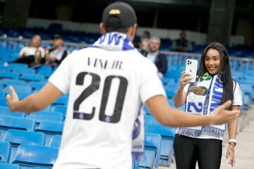 Una aficionada le hace una foto a un seguidor del Real madrid con la camiseta de Vini Jr.