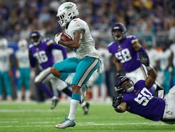 Torry McTyer (5), de los Miami Dolphins se quita la tacleada de Eric Wilson (50), de los Minnesota Vikings.