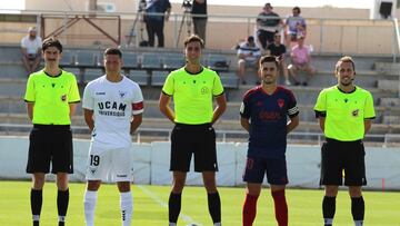 Manu Fuster, jugador del Albacete, posa junto al capitán del UCAM Murcia y el equipo arbitral antes de un partido.