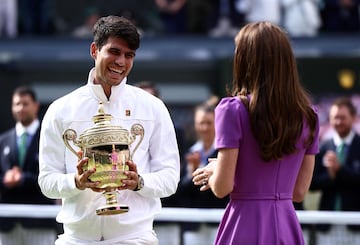 Britain's Catherine, Princess of Wales congratulates Spain's Carlos Alcaraz as he receives the winner's trophy after beating Serbia's Novak Djokovic during their men's singles final tennis match on the fourteenth day of the 2024 Wimbledon Championships at The All England Lawn Tennis and Croquet Club in Wimbledon, southwest London, on July 14, 2024. Defending champion Alcaraz beat seven-time winner Novak Djokovic in a blockbuster final, with Alcaraz winning 6-2, 6-2, 7-6. (Photo by HENRY NICHOLLS / AFP) / RESTRICTED TO EDITORIAL USE