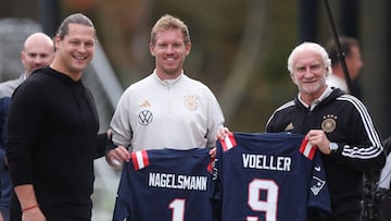 FOXBOROUGH, MASSACHUSETTS - OCTOBER 10:Former NFL player Markus Kuhn of Germany presents Julian Nagelsmann, head coach of Germany and Rudi Voller director of sport of Germany with NFL shirts bearing their names during a training session of the German national football team on October 10, 2023 in Foxborough, Massachusetts.   Alex Grimm/Getty Images/AFP (Photo by ALEX GRIMM / GETTY IMAGES NORTH AMERICA / Getty Images via AFP)