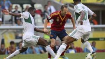 El centrocampista español Andrés Iniesta (dcha) pelea por el control del balón con los nigerianos Uwa Echiejile (izda) y John Obi Mikel