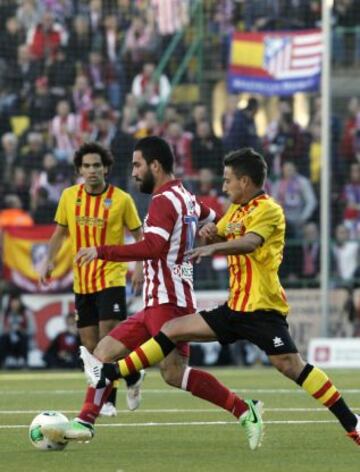 El centrocampista turco del Atlético de Madrid Arda Turan (c) conduce el balón ante Mouriño, jugador del Sant Andreu, durante el partido de ida de los dieciseisavos de final de la Copa del Rey, disputado esta tarde en el estadio Nacís Sala de Barcelona.