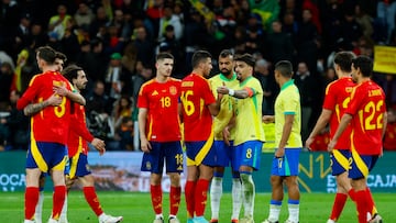 MADRID, 26/03/2024.- El centrocampista de la selección brasileña Lucas Paquetá (c-d) habla con Rodri, de España, durante el partido amistoso que las selecciones nacionales de fútbol de España y Brasil disputan hoy martes en el estadio Santiago Bernabéu, en Madrid. EFE/Mariscal
