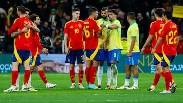 MADRID, 26/03/2024.- El centrocampista de la selección brasileña Lucas Paquetá (c-d) habla con Rodri, de España, durante el partido amistoso que las selecciones nacionales de fútbol de España y Brasil disputan hoy martes en el estadio Santiago Bernabéu, en Madrid. EFE/Mariscal
