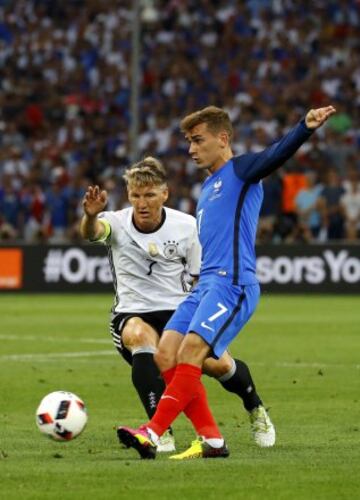 Griezmann plays the ball with Bastian Schweinsteiger in close attendance.