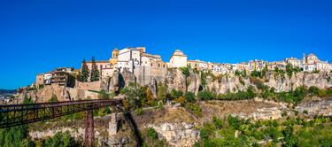 Puente colgante peatonal emblemático de la ciudad de Cuenca. Cruza la Hoz del Huécar y es famoso por ofrecer una de las vistas más impresionantes de las icónicas Casas Colgadas. El puente actual no es el original. El primer puente, de piedra, fue construido en el siglo XVI, pero se derrumbó con el paso del tiempo. El puente de hierro actual, con tablones de madera, fue inaugurado en 1902 y se construyó para unir el casco antiguo con el Convento de San Pablo, que hoy es el Parador de Turismo de Cuenca. Tiene una altura de 60 metros y una longitud de 100 metros.

 

