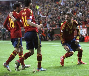 El defensa de la selección española de fútbol Sergio Ramos (d) celebra con sus compañeros, Sergi Busquets (c) y Francesc Fábregas (i), el gol marcado ante Finlandia, el primero del equipo,  durante el partido de la fase de clasificación para la Copa Mundial de la FIFA Brasil 2014 que ambos combinados disputan hoy en el estadio del Molinón.