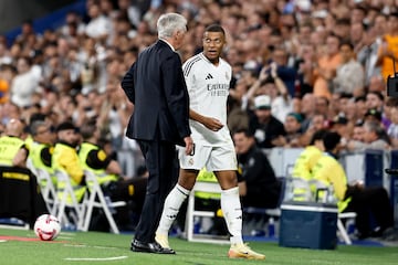 Mbappé le indica a Ancelotti su dolencia.