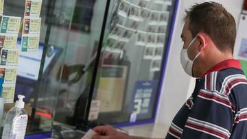 Archivo - Un hombre compra lotería en una administración