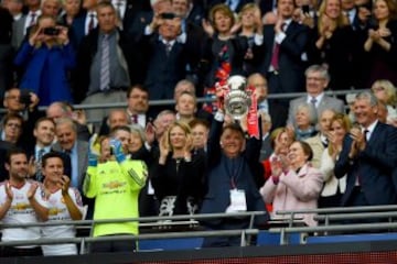 Louis van Gaal take his turn to lift the trophy.