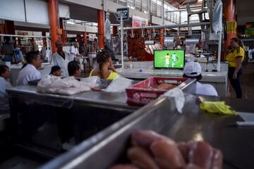 Los aficionados colombianos ven el partido en un mercado de Cali.