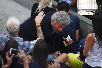 El periodista francés Nelson Monfort sujeta el micro entrevistando al cantante francés M. Pokora en medio de las gradas durante el partido de tenis.