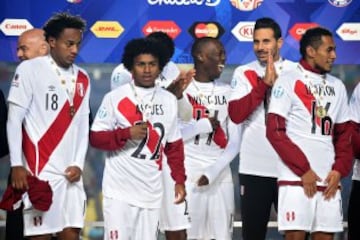 Peruvian players celebrate on the podium at the end of their Copa America third place football match against Paraguay in Concepcion, Chile on July 3, 2015. Peru won 2-0. AFP PHOTO / LUIS ACOSTA