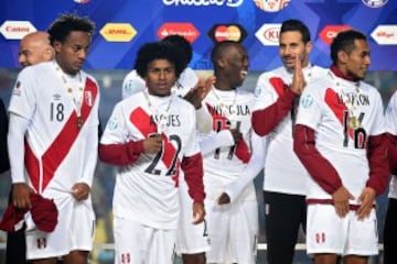 Peruvian players celebrate on the podium at the end of their Copa America third place football match against Paraguay in Concepcion, Chile on July 3, 2015. Peru won 2-0.  AFP PHOTO / LUIS ACOSTA