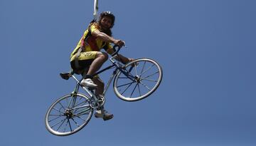 Un espectador montado en una bicicleta colgado de una grúa durante la etapa 19.