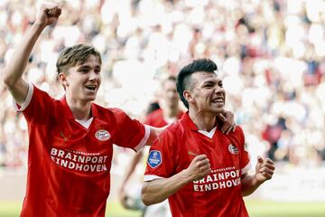 PSV's Mexican forward #27 Hirving Lozano (R) celebrates after scoring PSV's sixth goal with PSV's Dutch midfielder #31 Tygo Land (L) during the Dutch Eredivisie football match between PSV Eindhoven and Vitesse Arnhem at the Phillips stadium, in Eindhoven, on April 13, 2024. (Photo by MAURICE VAN STEEN / ANP / AFP) / Netherlands OUT