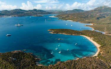Playa de piedra rojiza y arena rubia, orientada hacia el Parque Nacional del Archipiélago de La Maddalena, un paraíso ecológico por la pureza de sus aguas y su abundante fauna acuática.