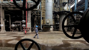 FILE PHOTO: A worker walks past oil pipes at a refinery in Wuhan, Hubei province March 23, 2012. REUTERS/Stringer/File Photo