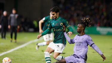 El delantero del Cacereño Miguel García (i) pelea un balón con Eduardo Camavinga, del Real Madrid, durante el partido correspondiente a los dieciseisavos de final de la Copa del Rey entre el Club Deportivo Cacereño y el Real Madrid disputado este martes en el Estadio Príncipe Felipe, en Cáceres.