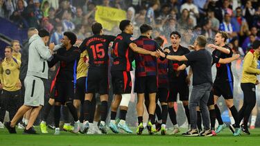 Los jugadores del Barcelona celebran la victoria y el título de liga con los aspersores abiertos.