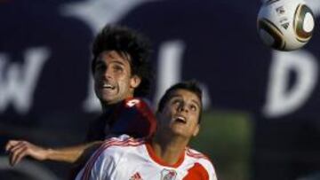 <b>PELEA. </b>Lamela salta a por la pelota con Pereyra, de San Lorenzo.