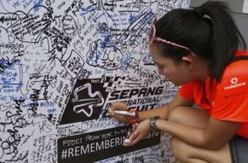 Una mujer escribe en una pared dedicada a los pasajeros de los desaparecidos Malaysia Airlines vuelo MH370 antes de la F1 Gran Premio de Malasia en Sepang.