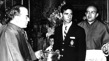 Luis Belló sujeta en el Pilar el trofeo de la Copa del Generalísimo de 1964 junto al capellán Juan Antonio Gracia.