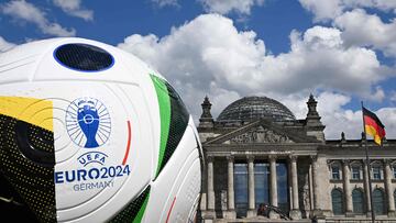 A giant ball of the upcoming UEFA Euro 2024 European Football Championship stands in front of the Reichstag building that houses the Bundestag (lower house of parliament) on June 13, 2024. (Photo by RALF HIRSCHBERGER / AFP)