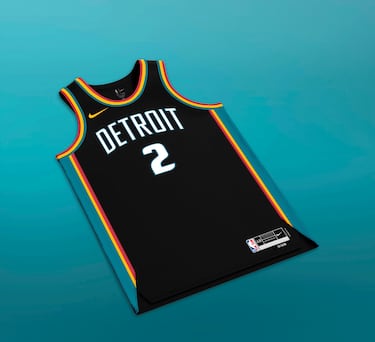 El uniforme City Edition de los Detroit Pistons para la temporada 2025/26 es negro con la palabra 'Detroit' en blanco en el pecho, acompañado por franjas laterales en verde azulado y detalles en burdeos. Es un diseño sobrio y moderno que representa la fuerza y el carácter de la ciudad, sin incluir el icónico caballo de otras versiones anteriores.