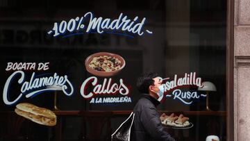 A man wearing a protective face mask walks past a closed restaurant amid the coronavirus disease (COVID-19) outbreak in Madrid, Spain, April 15, 2020. REUTERS/Sergio Perez