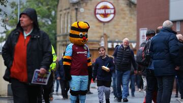 La mascota del Burnley pasea a las afueras de Turf Moor junto a los aficionados.