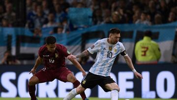 Argentina's Lionel Messi (R) and Venezuela's Miguel Navarro vie for the ball during their South American qualification football match for the FIFA World Cup Qatar 2022 at La Bombonera stadium in Buenos Aires on March 25, 2022. (Photo by Juan Mabromata / AFP)