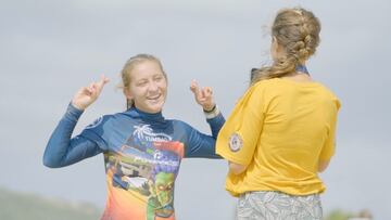 Una chica cruza los dedos con la licra de la Youth World Cup mientras otra le hace una foto vestida de amarillo, en la playa de Valdevaqueros (Tarifa), el 25 de septiembre del 2021. 