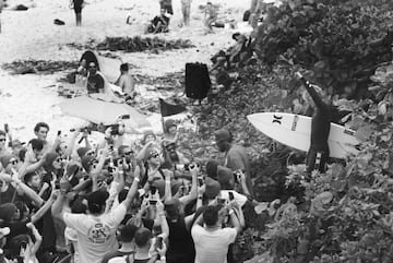 El surfista hawaiano levanta el puño ante amigos, familia, seguidores y periodistas.