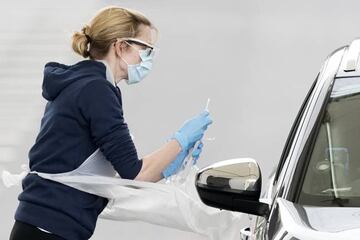 A nurse takes a swab at a Covid-19 drive-through testing station at Manchester Airport.