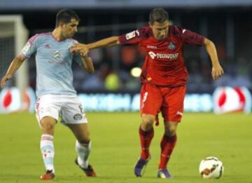 El centrocampista del Celta de Vigo Álex López (i) pugna por un balón con Roberto Lago, del Getafe, durante el partido de Liga de Primera División que se juega esta tarde en el estadio del Balaídos, en Vigo.