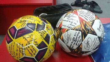 Leo Messi recibe firmados los balones de Liga y Champions