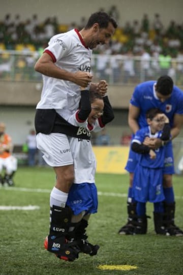 El futbolista brasileño Nene y el niño Rikellmy celebran un gol durante  un evento con niños discapacitados en Praia Grande (Brasil).