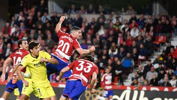 GRANADA, 30/10/2023.- El centrocampista del Granada, Sergio Ruiz (2d), cabecea el balón ante el delantero del Villarreal, Gerard Moreno, durante el encuentro correspondiente a la jornada 11 de primera división que disputan hoy lunes en el estadio Nuevo Los Carmenes de Granada. EFE / Miguel Ángel Molina.