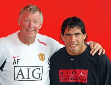 El futbolista argentino Carlos Tevez posando con Sir Alex Ferguson después de la firma de Tevez para el club.