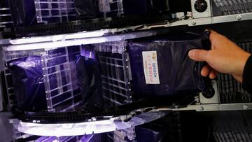 A staff member of Takenoko ENT Clinic replenishes a package containing a polymerase chain reaction (PCR) test for the coronavirus disease (COVID-19) to a vending machine at the entrance of a ramen noodle shop at Shibuya district in Tokyo, Japan March 8, 2021. REUTERS/Issei Kato