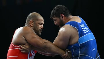 Chile's Yasmani Acosta Fernandez (red) wrestles Egypt's Abdellatif Mohamed (blue) during their men's greco-roman 130kg wrestling quarter-final match at the Champ-de-Mars Arena during the Paris 2024 Olympic Games, in Paris on August 5, 2024. (Photo by Luis ROBAYO / AFP)