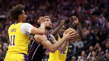 Domantas Sabonis, ala-pívot de Sacramento Kings, avanza ante Jaxson Hayes y Taurean Prince, de Los Angeles Lakers.
