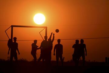 El fútbol entre aficionados en numerosas ocasiones nos deja imágenes como la de esta hermosa fotografía, en la que se puede observar cómo el sol se pone mientras un grupo de jóvenes iraquíes juega un partido en la ciudad sureña de Nasiriyah, en la provincia de Dhi Qar.